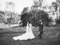 Black and white photo of bride and groom  by the side yard