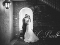 Black and white photo of bride and groom under the archway